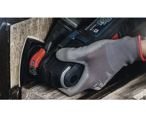 Eine Hand mit Arbeitshandschuh bedient ein Elektrowerkzeug zum Schleifen von Holz.