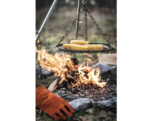 Gril avec épis de maïs sur feu ouvert et gant de barbecue