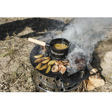 Ein Petromax Atago Grill mit Grillplatte, darauf Speisen und ein Petromax Topf