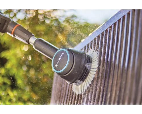 Brosse Gardena nettoyant une clôture avec de l''eau