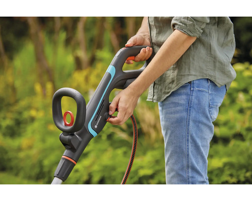 Personne utilisant un coupe-bordures Gardena dans le jardin