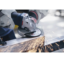 Un utilisateur meule du métal avec une meuleuse d''angle, des étincelles jaillissent