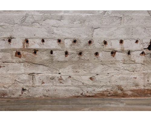 Un mur de briques avec des trous de forage