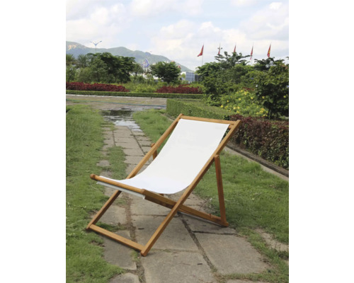 Chaise longue en bois avec revêtement en tissu dans le jardin.
