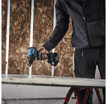 Une personne utilise une visseuse à plaques de plâtre sans fil Makita pour visser une plaque de plâtre.