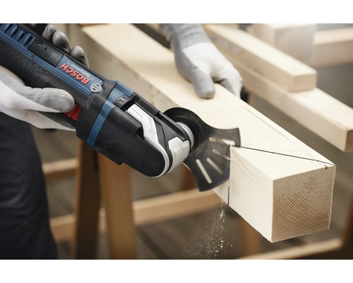 Outil multifonction coupant une pièce de bois.