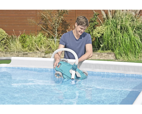 Un homme met un nettoyeur de piscine dans une piscine