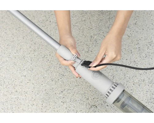 Eine Person schliesst das Kabel eines Poolreinigers an