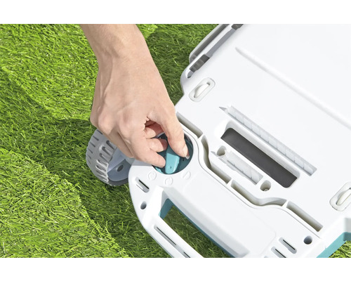 Une personne ajuste la hauteur de coupe d''une tondeuse à gazon.