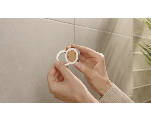 Hände befestigen magnetische Rosette an der Wand