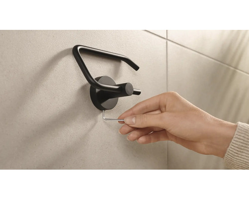 Montage eines Toilettenpapierhalters mit einem Innensechskantschlüssel.