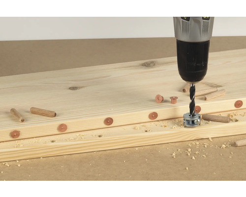 Des planches de bois sont assemblées à l''aide d''une perceuse, de chevilles et de douilles.