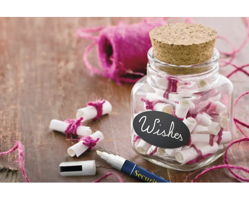 Glas mit Wunschzetteln, Kordel und Stift auf einem Tisch