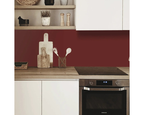 Küchenszene mit Arbeitsplatte, Spüle und Küchenutensilien vor einer farbigen Küchenrückwand