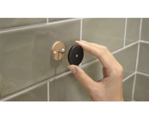 Wandhaken mit Abdeckung wird an Fliesen angebracht