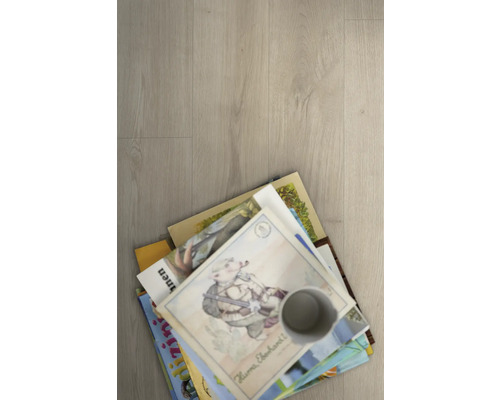 Pile de livres pour enfants et tasse sur un revêtement de sol.