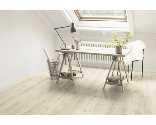 Pièce lumineuse avec sol stratifié, bureau sur tréteaux et fenêtre de toit pour une ambiance conviviale.