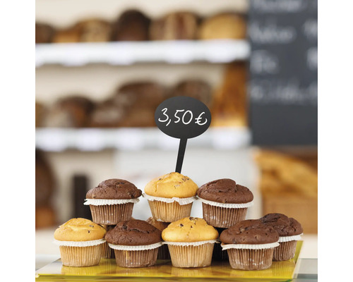 Auf einem Tisch stehen Muffins und ein Preisschild.