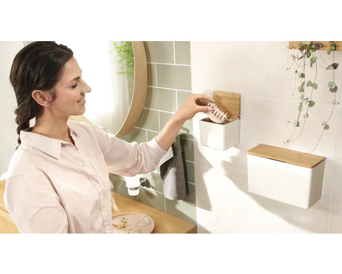 Scène de salle de bains avec femme, lavabo et boîtes murales en acier avec couvercle en bambou