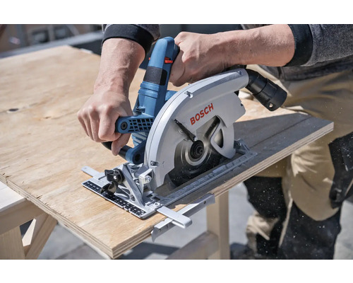 Eine Person sägt mit einer Bosch Handkreissäge ein Holzbrett.