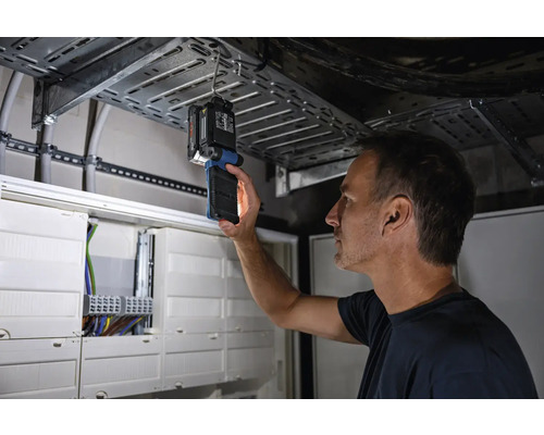 Un homme inspecte une installation électrique avec une lampe d''inspection.