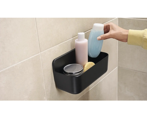 Schwarzer Duschkorb mit Pflegeprodukten an der Wand