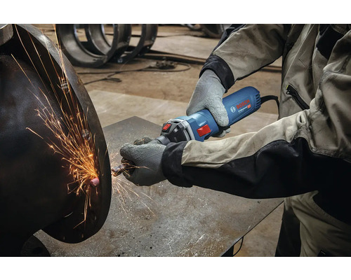 Eine Person benutzt einen Geradschleifer zum Schleifen von Metall, wobei Funken entstehen.