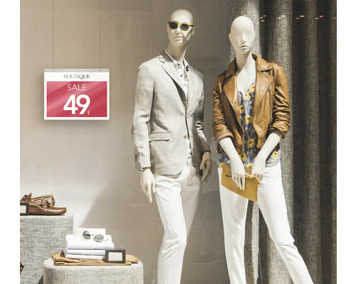 Schaufensterpuppen präsentieren Herrenbekleidung und Damenbekleidung hinter einer Verkaufsanzeige