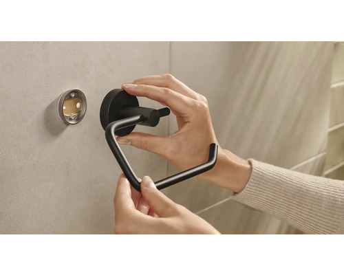Installation eines schwarzen Toilettenpapierhalters an der Wand