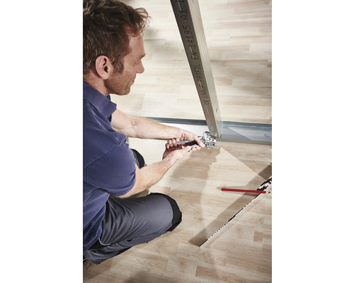 Mann befestigt Metallprofil mit Zange im Trockenbau