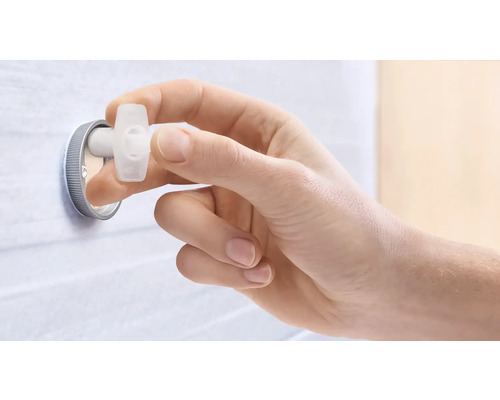 Eine Hand betätigt einen Eckregulierungsstopfen.