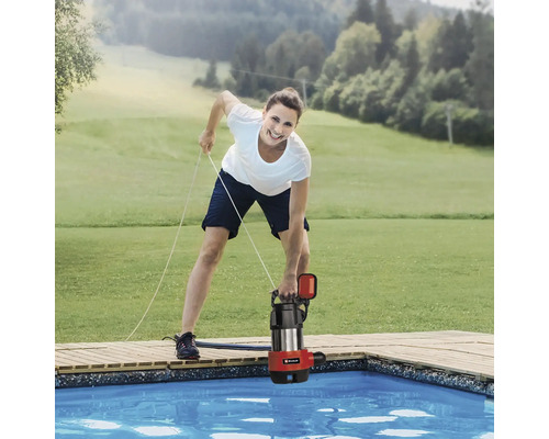 Femme abaissant une pompe à eau sale dans une piscine