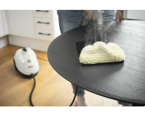 Dampfreiniger im Einsatz auf einem runden Tisch für die Reinigung