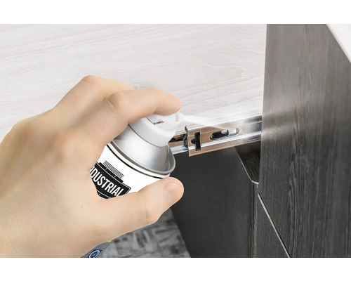 Eine Person sprüht Gleitschienen mit einem Schmierspray ein.