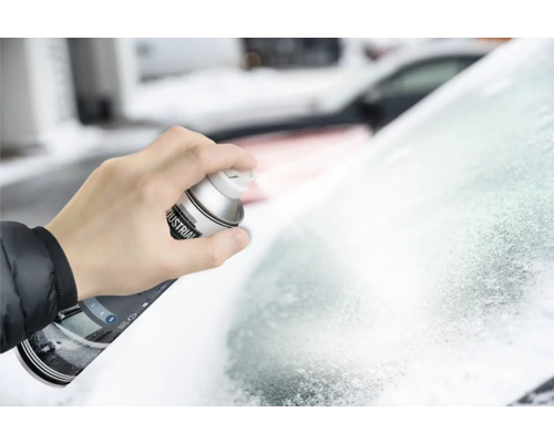 Eine Hand sprüht Enteiserspray auf eine vereiste Windschutzscheibe.