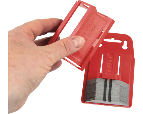 Packung mit Cuttermesserklingen mit einer Hand, die den Deckel öffnet