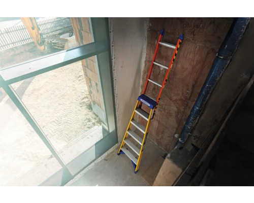 Stehleiter in Baustelle neben einem Fenster