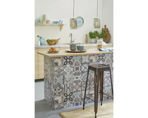 Îlot de cuisine avec motif mosaïque et tabouret de bar dans une cuisine claire.