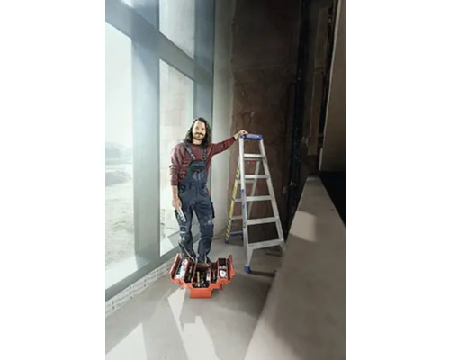 Handwerker mit Werkzeugkoffer und Leiter in einem hellen Raum.