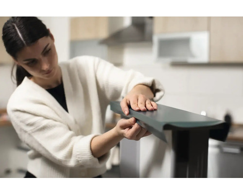 Femme assemblant un meuble dans une cuisine