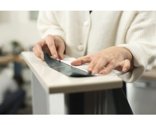 Person bringt Folie auf eine Oberfläche auf.