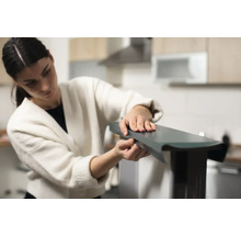 Femme assemblant un meuble dans la cuisine.