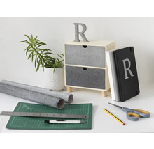 Scène de décoration avec commode, plante, carnets et matériel de bricolage