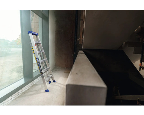 Aluminium-Leiter im Innenbereich neben einem Fenster