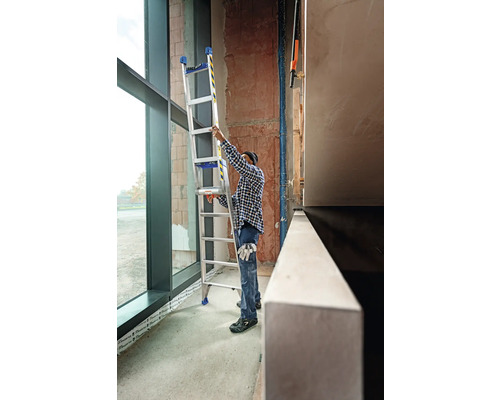 Handwerker platziert eine Mehrzweckleiter in einem Gebäude.