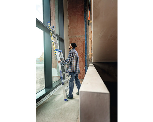 Eine Person hält eine Mehrzweckleiter in einem Raum mit einem großen Fenster.