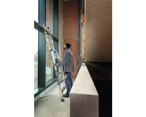 Handwerker mit Trittleiter in einem Gebäude im Rohbau