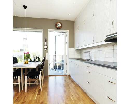 Helle Küche mit Esstisch und Zugang zum Balkon.