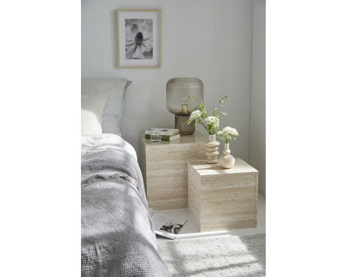 Scène de chambre à coucher avec lit, tables de chevet, lampe, vases, image et objets de décoration.