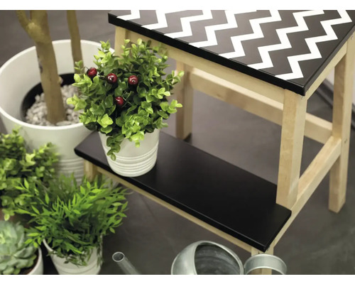 Dekorative Szene mit Tritthocker, Pflanzen und Gießkanne